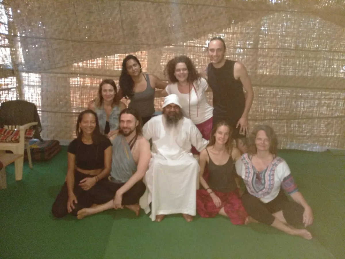 Swami-ji seated in white with a course group around him