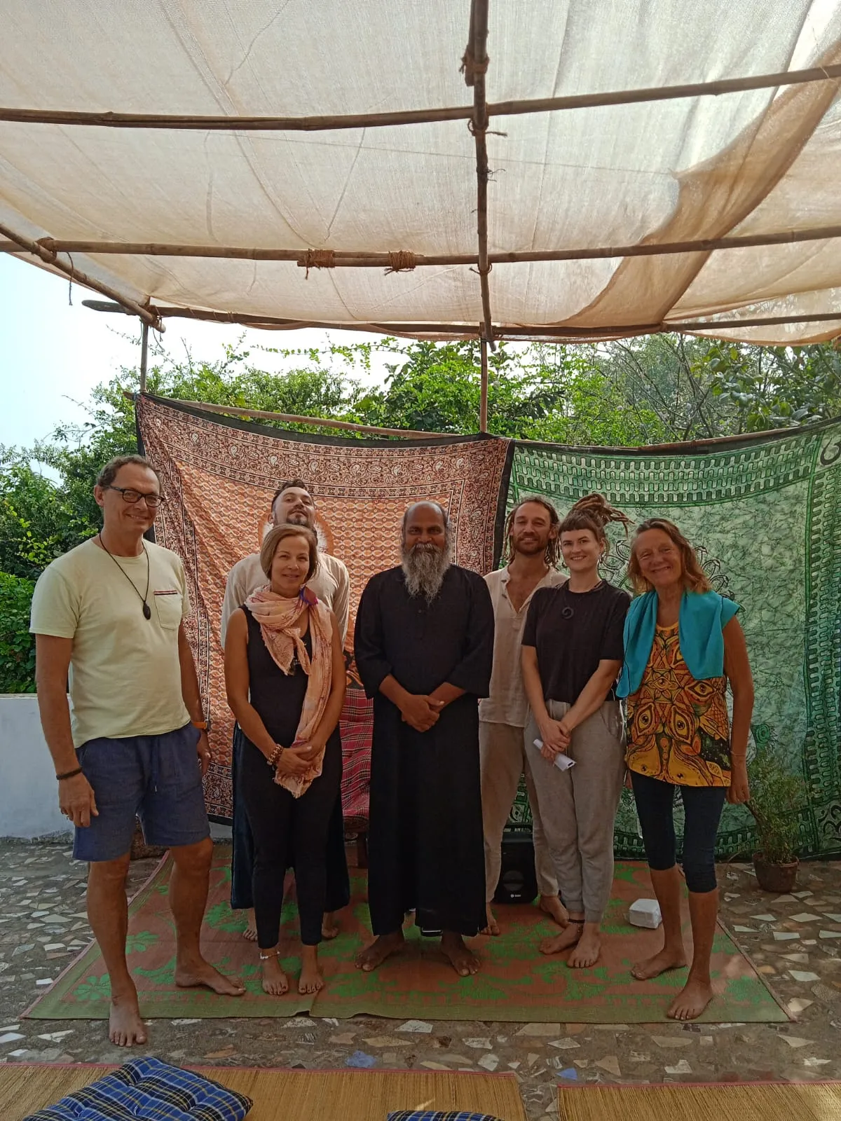 A small course group standing under a canopy on a rug