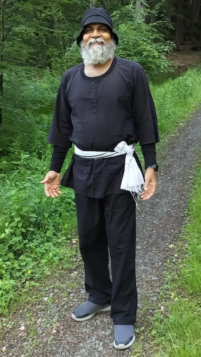 Swami-ji on a woodland path among summer green