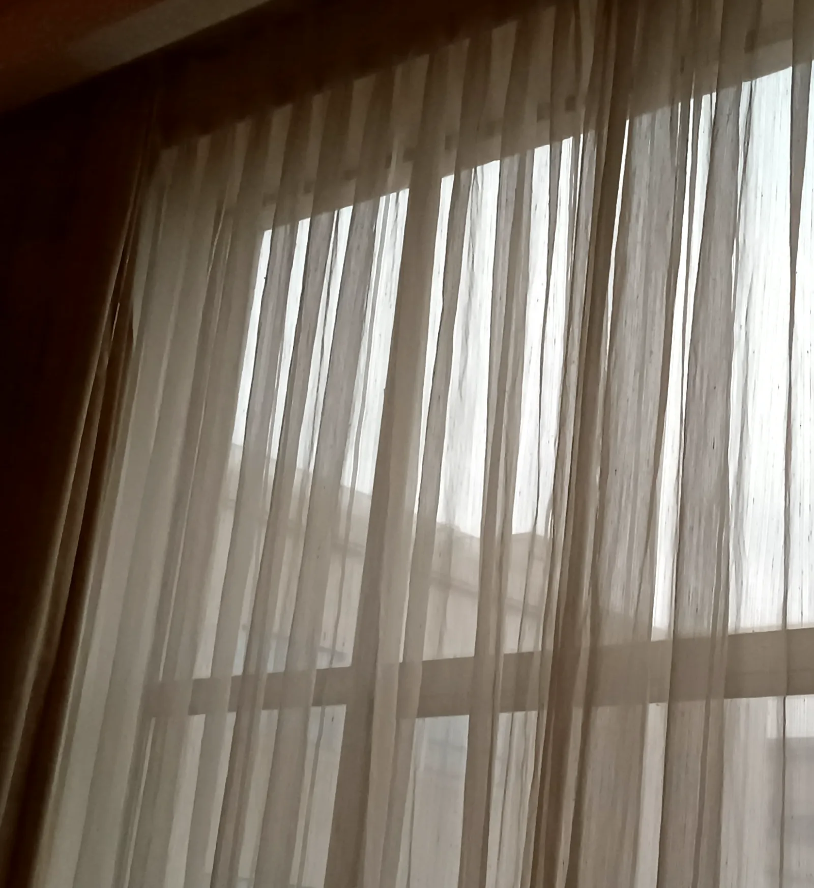 Daylight falling through a sheer curtain into an uncluttered room